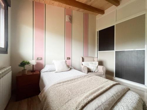 a bedroom with a bed and a chair and a window at CASA VISTA SIERRA in Jaraiz de la Vera