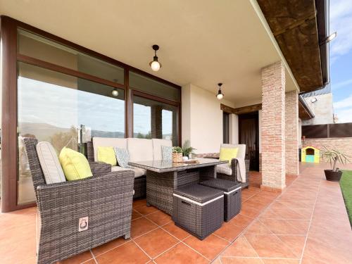 an outdoor patio with wicker chairs and a table at CASA VISTA SIERRA in Jaraiz de la Vera