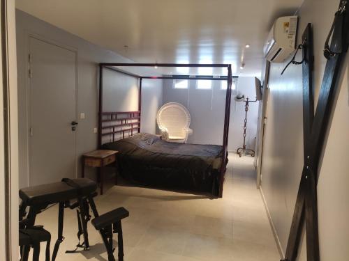 een slaapkamer met een bed en een stoel erin bij Chambre Secret Room, Riad 3 Couple only au village naturiste in Cap d'Agde