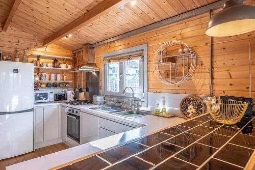 a kitchen with white appliances and wooden walls at The Cabin, Parham in Woodbridge