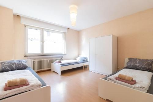 a bedroom with two beds and a large window at Monteurwohnung im schönen Essenheim bei Mainz in Essenheim