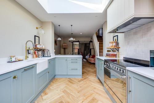 a large kitchen with blue cabinets and wooden floors at *NEW* Little Pyecroft House, Chester in Chester