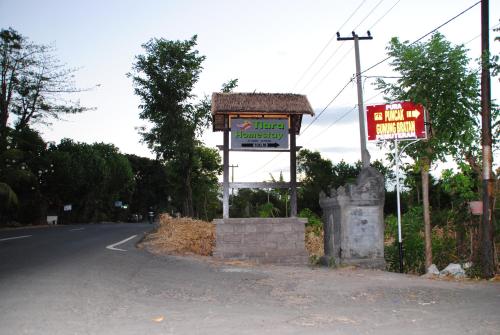 a sign for a hotel on the side of a road at Tiara Homestay Pemuteran Bali in Pemuteran