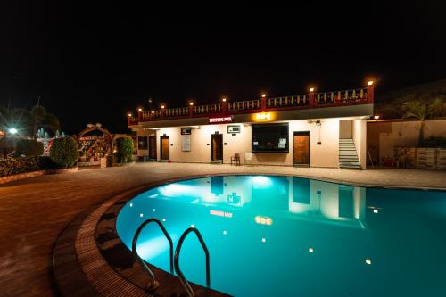 a swimming pool in front of a house at night at Hotel Royal Palace in Sāgar
