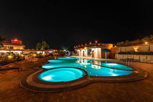 a large swimming pool at night with lights at Hotel Royal Palace in Sāgar