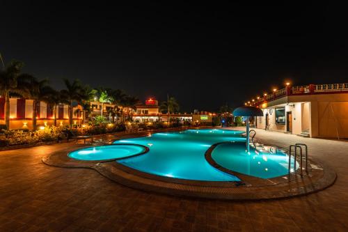a swimming pool at night with blue lighting at Hotel Royal Palace in Sāgar