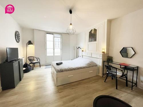 - une chambre avec un lit, une table et des chaises dans l'établissement Le Grand'rue by iZiLi - Centre Ville - Confort, à Poitiers