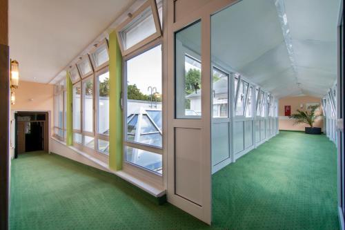 a corridor of an office building with green floors and windows at Seehotel Grunewald in Berlin