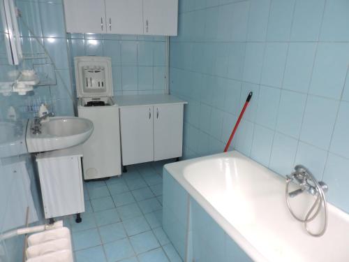 uma casa de banho com um lavatório e uma banheira e um lavatório em Góbé Vendégház em Sovata