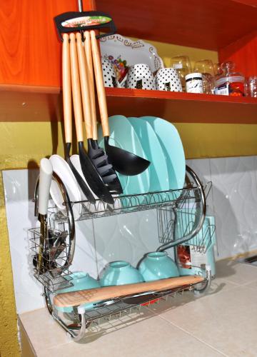 un estante de platos con platos y utensilios en la cocina en one bedroom in oj town ruiru, en Kiambu
