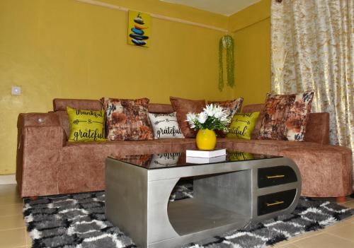 a living room with a couch with a tv on a table at one bedroom in oj town ruiru in Kiambu