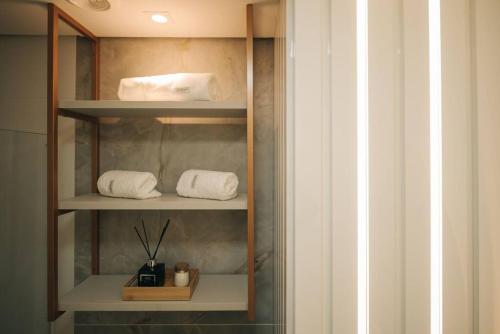 佩洛塔斯Loft com sacada, lareira e garagem no Parque Una的浴室内带毛巾和毛巾的架子