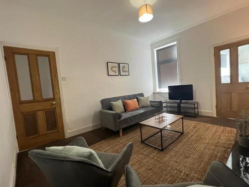 uma sala de estar com um sofá e uma mesa em Alexander Apartments West Harton em South Shields