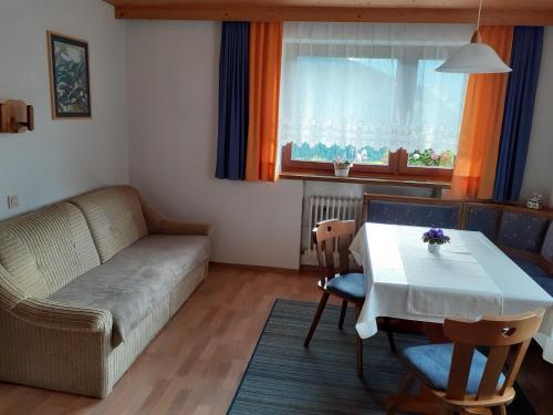 ein Wohnzimmer mit einem Sofa und einem Tisch in der Unterkunft Ferienwohnung Reinstadler in Jerzens