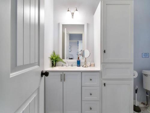 a white bathroom with a sink and a mirror at Golden Vibes Dwtn,Eado,Nrg,MedCtr,MTR,Rodeo in Houston