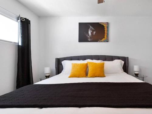 a bedroom with a large bed with yellow pillows at Golden Vibes Dwtn,Eado,Nrg,MedCtr,MTR,Rodeo in Houston