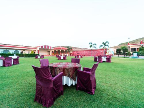 a table and chairs on the grass in a field at Hotel Royal Palace in Sāgar