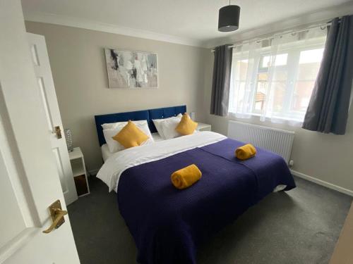 a bedroom with a blue and white bed with yellow pillows at President Road- A Spacious and homely four bed house by Catchpole Stays in Lexden