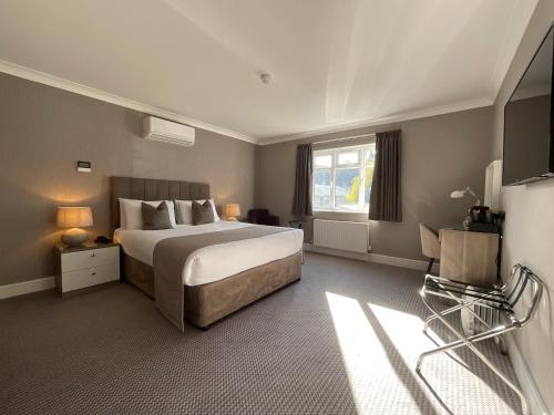 a hotel room with a bed and a television at The Riverside in Salisbury