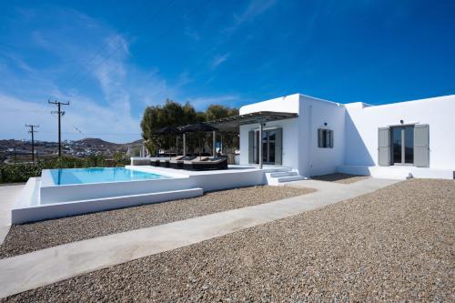 a white villa with a swimming pool and a house at Private Villa Màou in Ano Mera