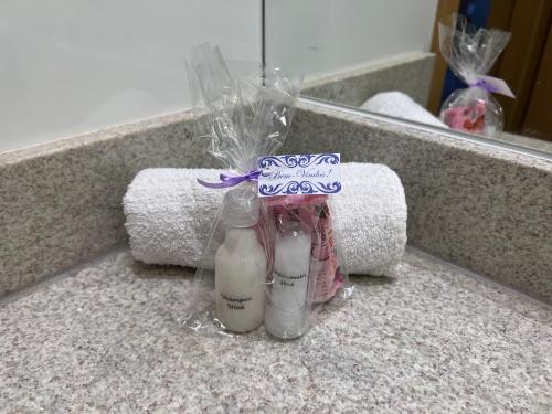 a bathroom counter with two bottles of soap and towels at Apartamento no Jardim Goiás em Goiânia in Goiânia