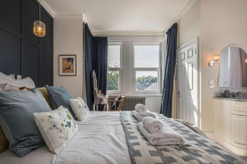 a bedroom with a large bed with towels on it at Westfield Lodge: Charming 4 bed, 4 bath house in Broadstairs in Kent