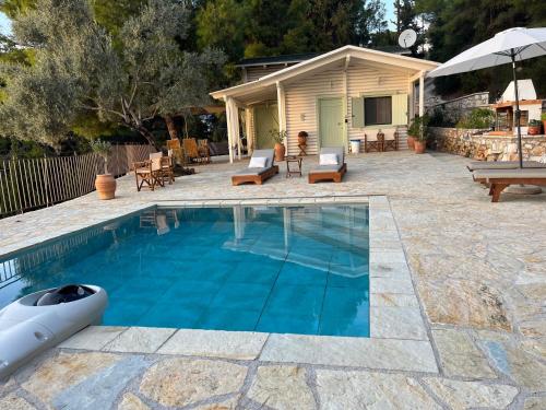 a swimming pool with a patio and a house at The White House above Egremni in Athanion