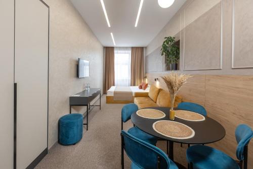 a room with a table and chairs and a bed at Jam Apartments Miskevycha in Lviv