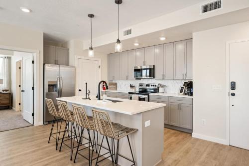 een keuken met witte kasten en een eiland met barkrukken bij Hummingbird Retreat condo in Atkinville