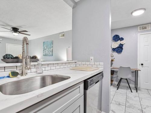 a white kitchen with a sink and a table at The Flower Rm Dwntn,MedCtr,eado, TSU,Rodeo in Houston