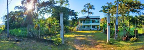 una casa en medio de un patio con árboles en Pacífico Sul Suítes, en Ubatuba