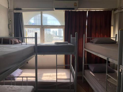 Zimmer mit 3 Etagenbetten und einem Fenster in der Unterkunft Room Bangkok in Godown