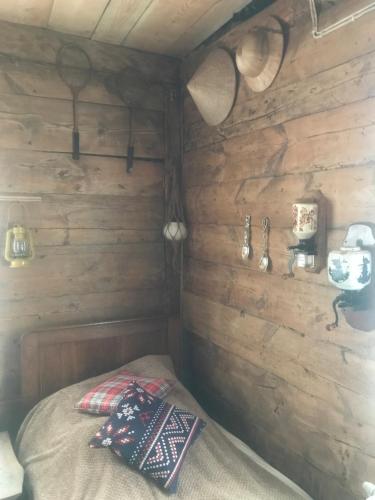 een slaapkamer met een bed in een houten hut bij Ślimakowa chatka in Parczew