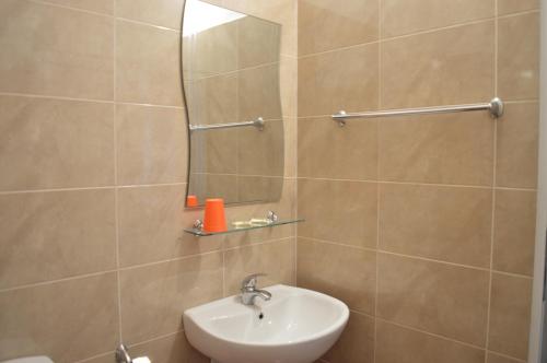 ein Bad mit einem Waschbecken und einem Spiegel in der Unterkunft Hotel Paradise in Lozenets