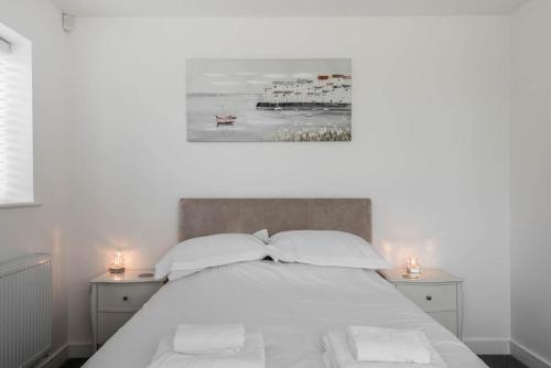 a bedroom with a white bed with two night stands at The Montague: Newly built two bedroom apartment with parking in Kent