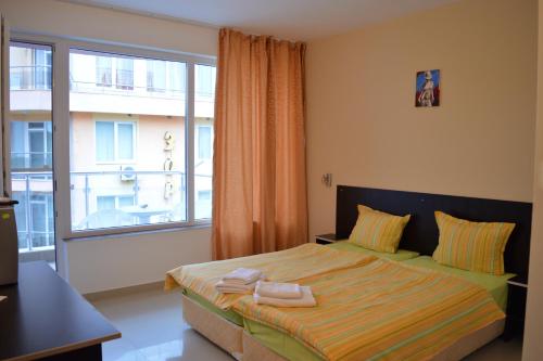 1 dormitorio con cama y ventana grande en Hotel Paradise, en Lozenets