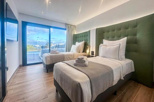 1 Schlafzimmer mit 2 Betten und einem großen Fenster in der Unterkunft Villa Infinity in Playa Blanca