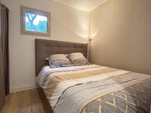 un lit dans une chambre avec une fenêtre dans l'établissement Appartement T2 vue mer, piscine et stationnement., à Six-Fours-les-Plages