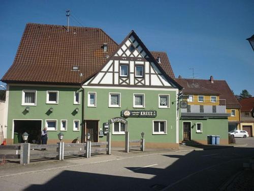 a green building with a black and white roof at Landgasthof Kreuz mit Gästehaus in Immendingen