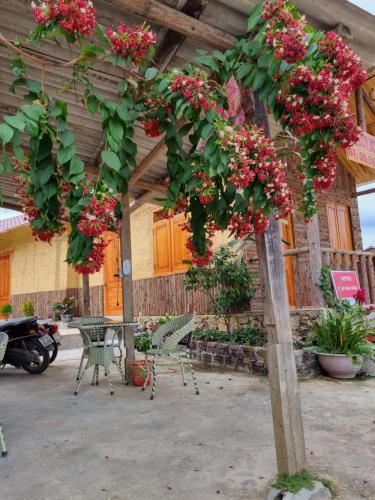 un arbre avec des fleurs rouges sur un poteau en bois dans l'établissement Vạn Duy Homestay, à Quản Bạ