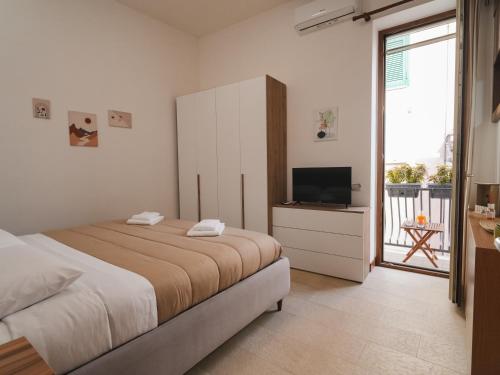 um quarto com uma cama e uma televisão de ecrã plano em Da Sara em Pozzuoli