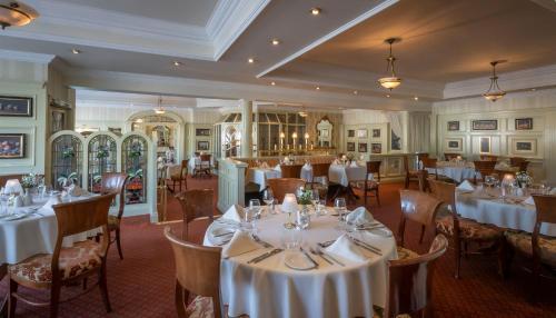 un comedor con mesas y sillas blancas en Granville Hotel, en Waterford