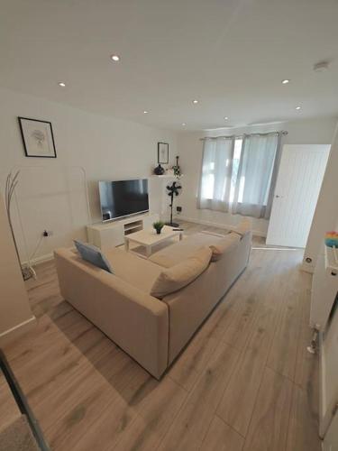 a living room with a couch and a television at Stunning 4 bed House Ideal for Contractors in Southampton