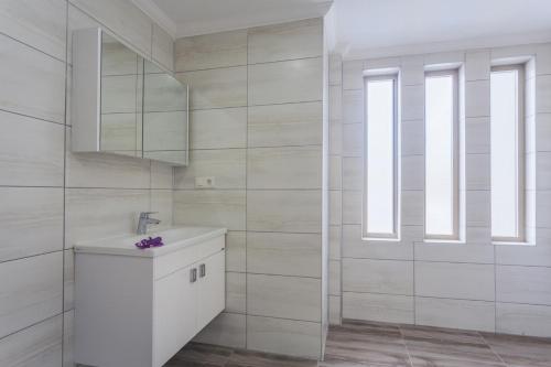 ein weißes Badezimmer mit einem Waschbecken und einem Spiegel in der Unterkunft Villa Moderno B in Oludeniz