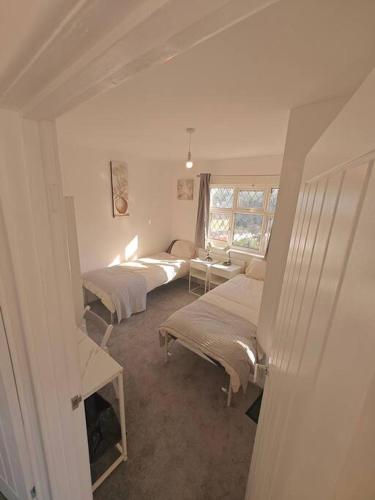 a bedroom with two beds and a window at Stunning 4 bed House Ideal for Contractors in Southampton