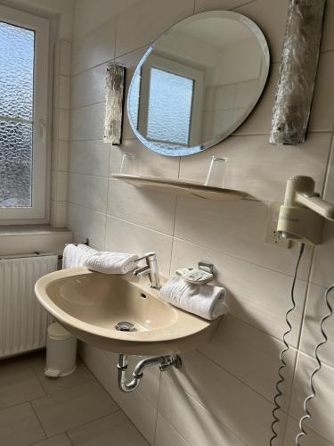 a bathroom with a sink and a mirror at Hotel Schnepper in Attendorn