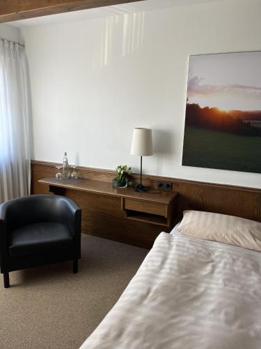 1 dormitorio con cama, escritorio y silla en Hotel Schnepper, en Attendorn