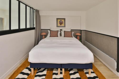パリにあるEdgar Suites Louvre - Richelieu 2のベッドルーム1室(白い大型ベッド1台付)
