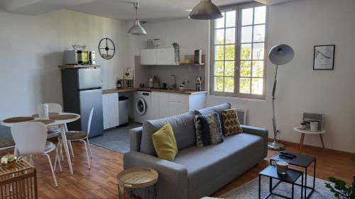 a living room with a couch and a kitchen at Appart' Cosy en Bord de Loire in Saumur