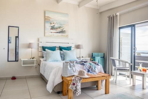 a bedroom with a bed and a table and a chair at Forever Blue in St. Helena Bay
